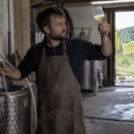 Naturwein-Winzer prüft einen jungen Weißwein im Keller