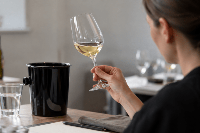 Systematische Weinverkostung mit Weißwein und Spucknapf